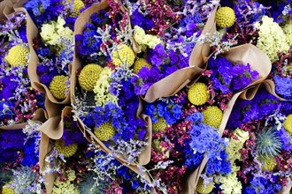 Several bundled flower arrangements in vivid shades of purple and yellow, flower sale, Central