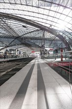 Spacious station concourse with glass roof and reflective surfaces, Berlin Central Station, Berlin,