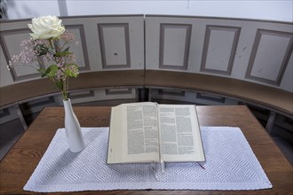 Open Bible next to a vase of flowers with a white Rose in the Protestant Reformed Church from 1401