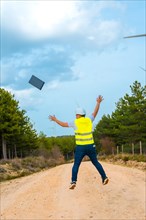 Vertical photo of the rear view of a male adult caucasian happy engineer jumping celebrating in a