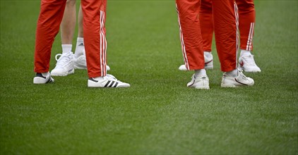 Legs, feet of FC Bayern Munich players, Adidas, logo, shoes, training trousers, on grass, MHPArena,