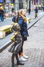 Bronze sculpture Fearless Girl by Kristen Visbal on Broad Street opposite the New York Stock