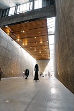 Wide museum hall with concrete walls, wooden ceiling and monumental sculpture, Koenig Galerie,