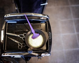 Tray of a hairdresser with mixed hair colour, scissors and comb, taken in the hairdressing salon