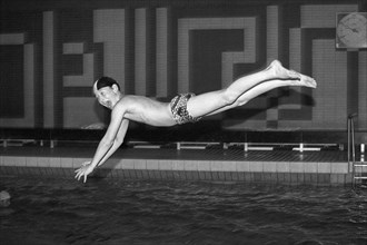 Boy jumps from three-metre board, head dive, indoor swimming pool, Bamberg, Upper Franconia,