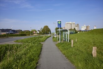 Bus stop Fischersiedlung with cycle path and silos in the harbour of Husum, district of