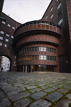 Round historic brick building with arched windows under a cloudy sky, Berlin, Germany, Europe