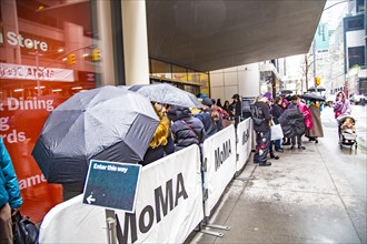 Queue in the rain in front of the Museum of Modern Art MoMa, Midtown Manhattan, New York City
