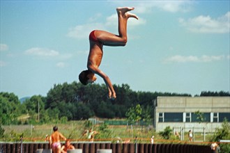 Boy jumping from three-metre board, outdoor swimming pool, Bamberg, Upper Franconia, Bavaria,