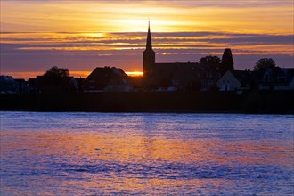 Rhine at sunset with the church of St Dionysius in Volmerswerth, Duesseldorf, Lower Rhine, North