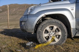 Compressor, inflating a car tyre, off-road vehicle, Kyrgyzstan, Asia