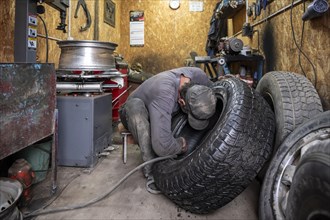 Workshop, man repairing a hole in a car tyre, Kyrgyzstan, Asia