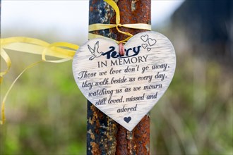 Heart shaped in memory message tied by ribbon to metal post, Felixstowe, Suffolk, England, UK