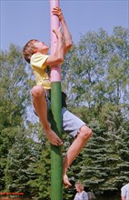 Boy climbs on maypole, barefoot, Heiligenthal, Lower Saxony, Germany, 20/06/1992, vintage, retro,