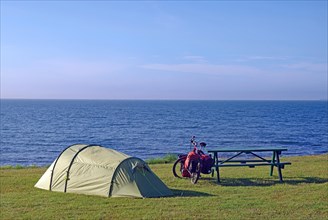 Tent and bike in a meadow with a view of the open sea, Cycling holidays, Outdoor, Husavik, Iceland,