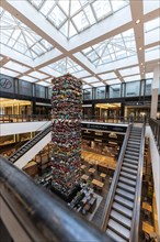 Multi-storey shopping centre with escalators and a central art installation, Berlin, Germany,