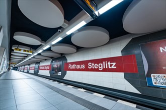 Modern underground station with advertising on pillars and platform in clear lines, Rathaus