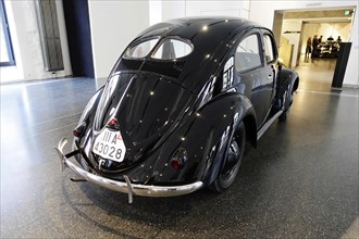 A black Volkswagen Beetle vintage car is shown in an exhibition room, AUTOMUSEUM PROTOTYP, Hamburg,