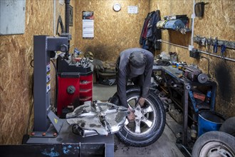 Workshop, man repairing a hole in a car tyre, Kyrgyzstan, Asia