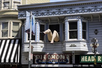 The facade of an urban building with decorative bay windows and various signs, San Francisco, North