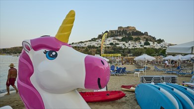 Giant inflatable unicorn on the beach with a castle in the background, Paulus Bay, below the