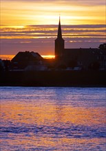 Rhine at sunset with the church of St Dionysius in Volmerswerth, Duesseldorf, Lower Rhine, North