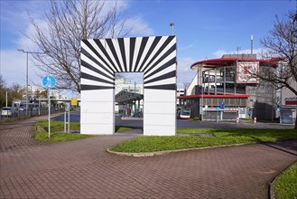 La Porta Aperta, sculpture by artist Marcello Morandini with bus station and Kaufland multi-storey