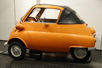A small orange vintage car with an open roof in an exhibition, AUTOMUSEUM PROTOTYP, Hamburg,
