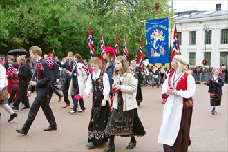 People in traditional costumes waving flags on the streets, folklore, bank holidays 17 May,
