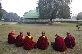 Tibetan monks, reciting sacred texts, tablet, smartphone, buddhism, stupa, Vaishali, Bihar, India,