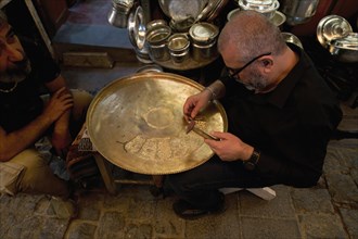 Coppersmith at work engraving a copper plate, Gaziantep bazaar, Turkey, Asia