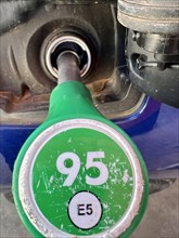 Male hand filling the gas tank of the car. Close-up of man hand supplying gasoline to vehicle.