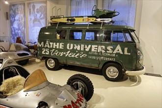 VW Transporter T1, Green Volkswagen bus with roof rack and surfboard in a car museum, AUTOMUSEUM