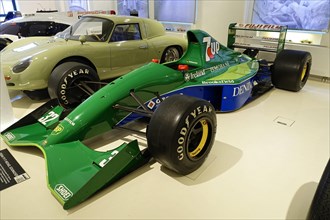 JORDAN 191 F1 MICHAEL SCHUHMACHER, A green Jordan Formula 1 racing car with sponsors in a showroom,