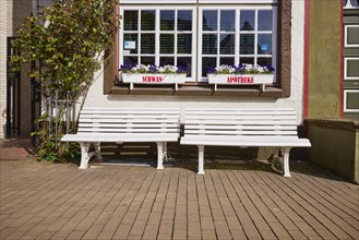 Benches and windows with flower boxes at the Swan pharmacy in the city centre of Husum,