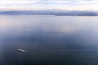 Ships on Lake Constance, wave structure, the mountains of the Swiss Alps are covered with snow,