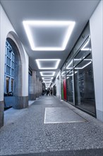 An illuminated passageway with modern architecture and a cool atmosphere at dusk, Berlin, Germany,