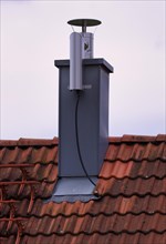 Retrofitted chimney on roof, with dust separator, electrostatic filtering of soot particles from