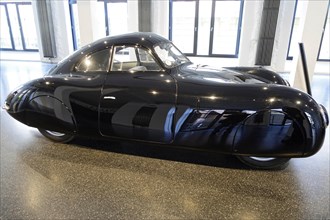 1939 PORSCHE TYPE 64 VW TYPE 60, side view of an elegant black Porsche sports car in an exhibition