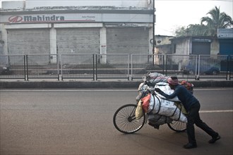 Man, carrying on bike, street, coal, selling to urban dwellers, restaurants, shops, Dhanbad, Bihar,