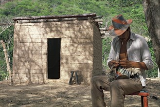 Wayuu tribe, man, making, traditional hat, house, La Guajira, Colombia, South America