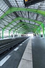 S-Bahn station with striking green roof and empty tracks on a bright day, Berlin, Germany, Europe