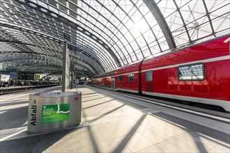 Train station with a red train, rubbish disposal and clear signage, Berlin Central Station, Berlin,