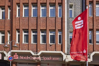 Nord-Ostsee Sparkasse with facade and flag in Husum, district of Nordfriesland, Schleswig-Holstein,