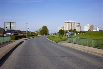 Street, bus stop Fischersiedlung and silos in the harbour in Husum, Nordfriesland district,