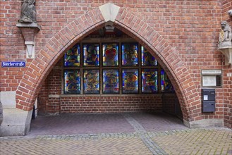 Brick building with arch and illuminated colourful windows in Boettcherstrasse, Bremen, Hanseatic