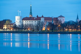 Riga Castle, seat of the Latvian President, in front of the Daugava River at blue hour, Riga,
