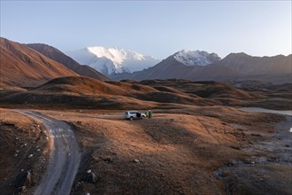 Aerial view, off-road car camping in the wilderness in front of Lenin Peak, Kyrgyzstan, Asia