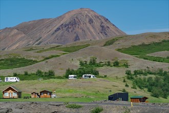 Campsite with huts and a prominent volcanic mountain, Myvatn, Reykjahlio, Iceland, Europe