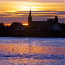 Rhine at sunset with the church of St Dionysius in Volmerswerth, Duesseldorf, Lower Rhine, North